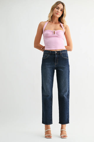 Woman wearing a pink top and blue jeans on a white background